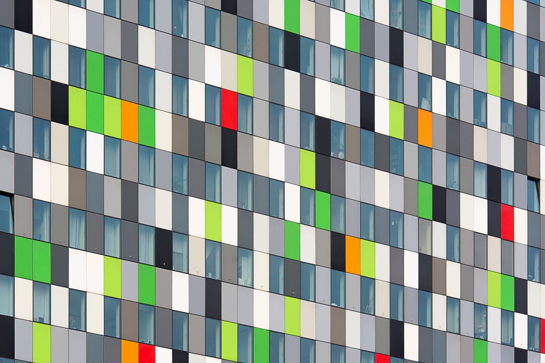 Vibrant geometric facade featuring multicolored panels and windows in a modern architectural design.