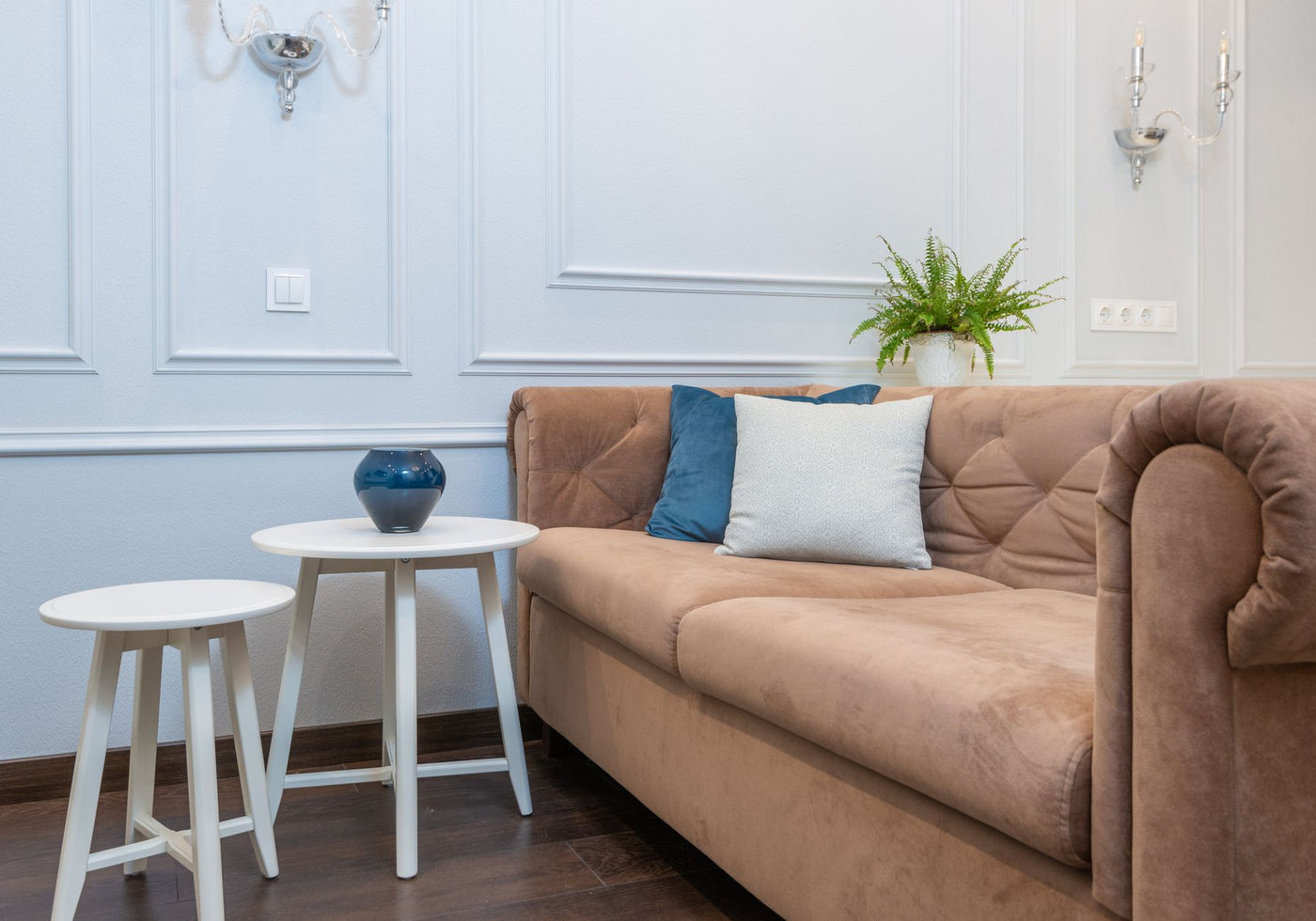 A cozy living room featuring a stylish sofa, pillows, and a white coffee table, perfect for relaxation.