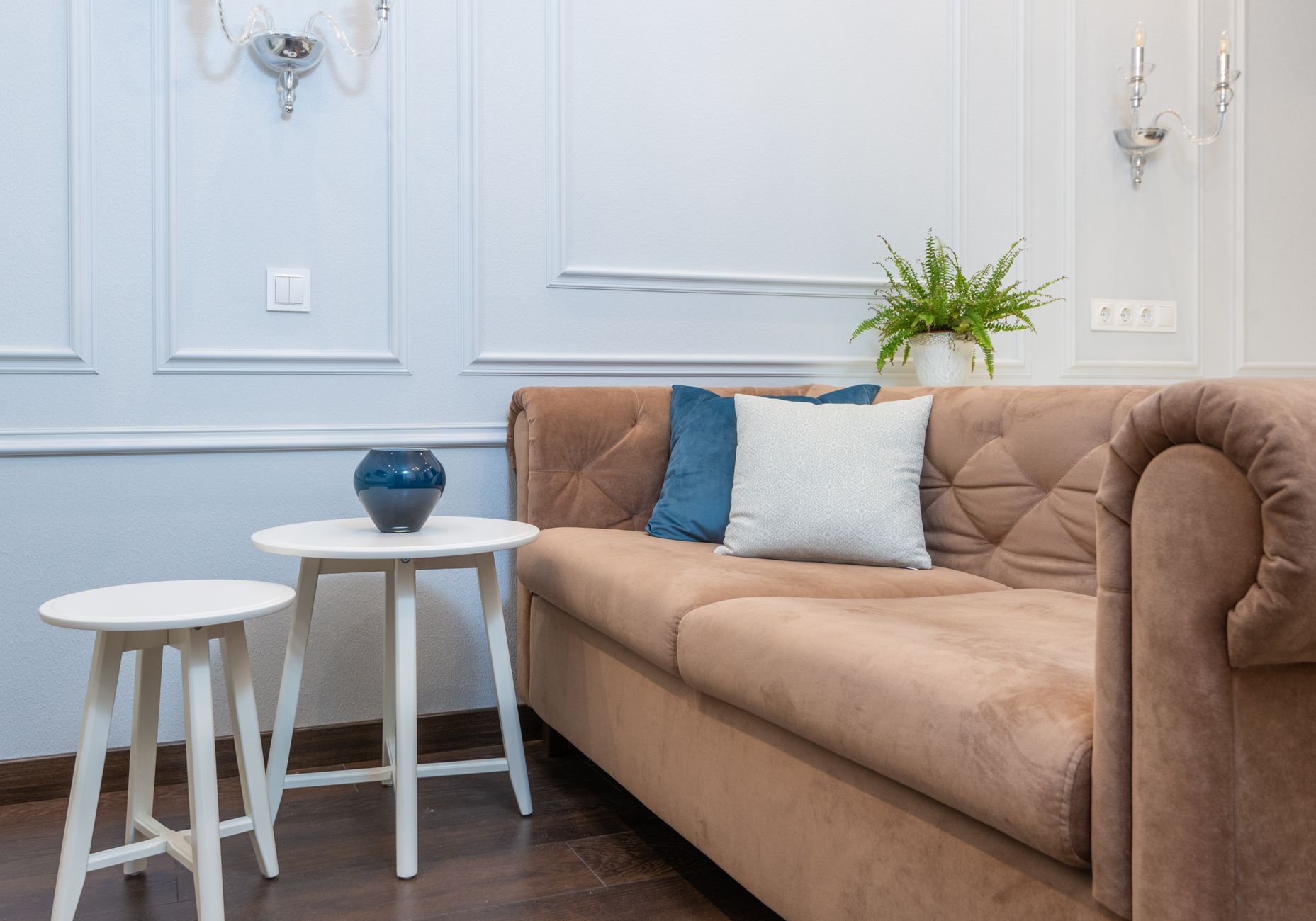 A cozy living room featuring a stylish sofa, pillows, and a white coffee table, perfect for relaxation.