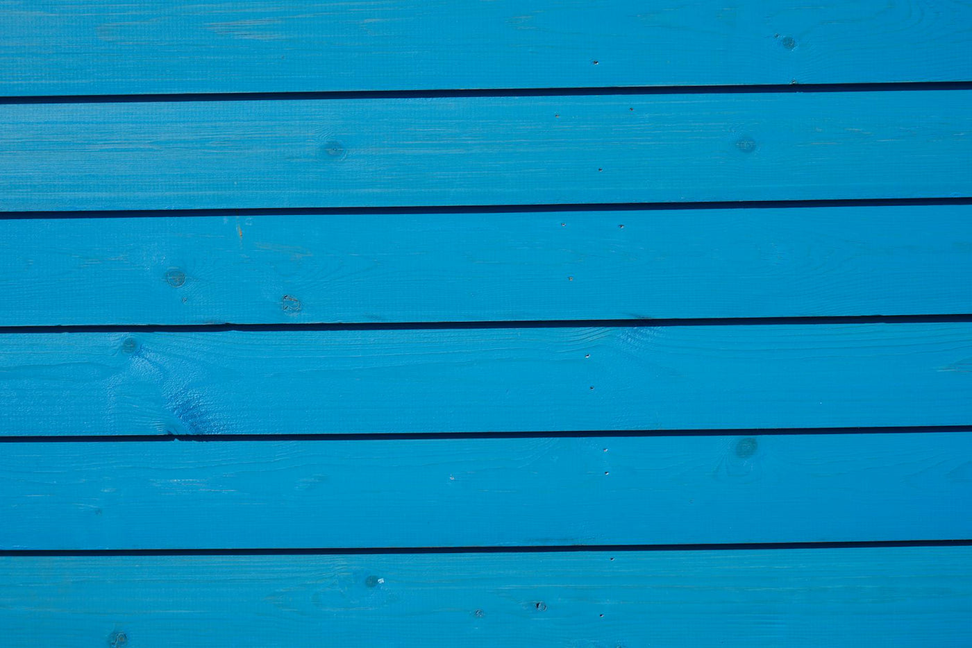 Close-up of vibrant blue wooden paneling with a detailed texture, ideal for backgrounds.