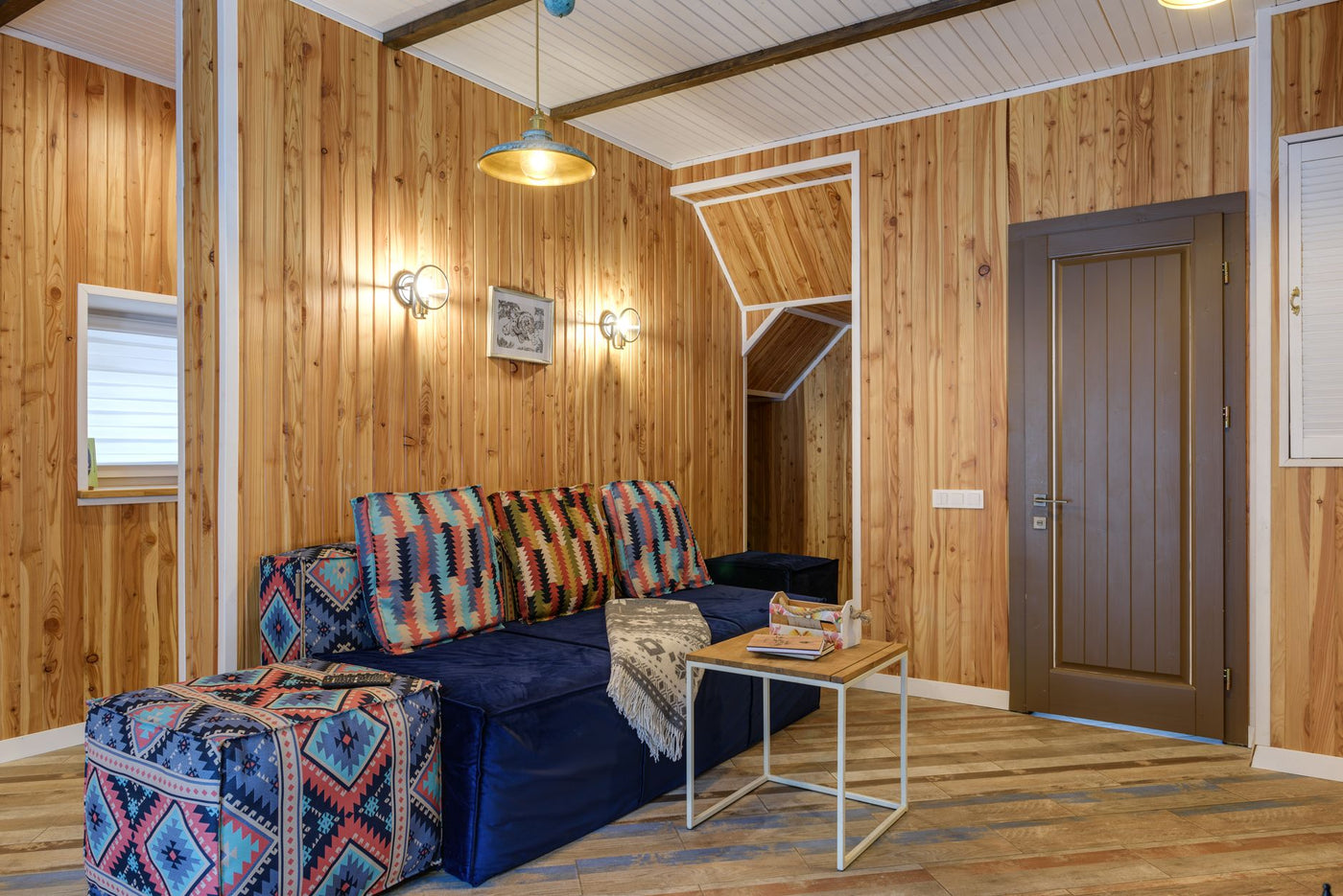 Warm and inviting living room with wooden walls and colorful furnishings.