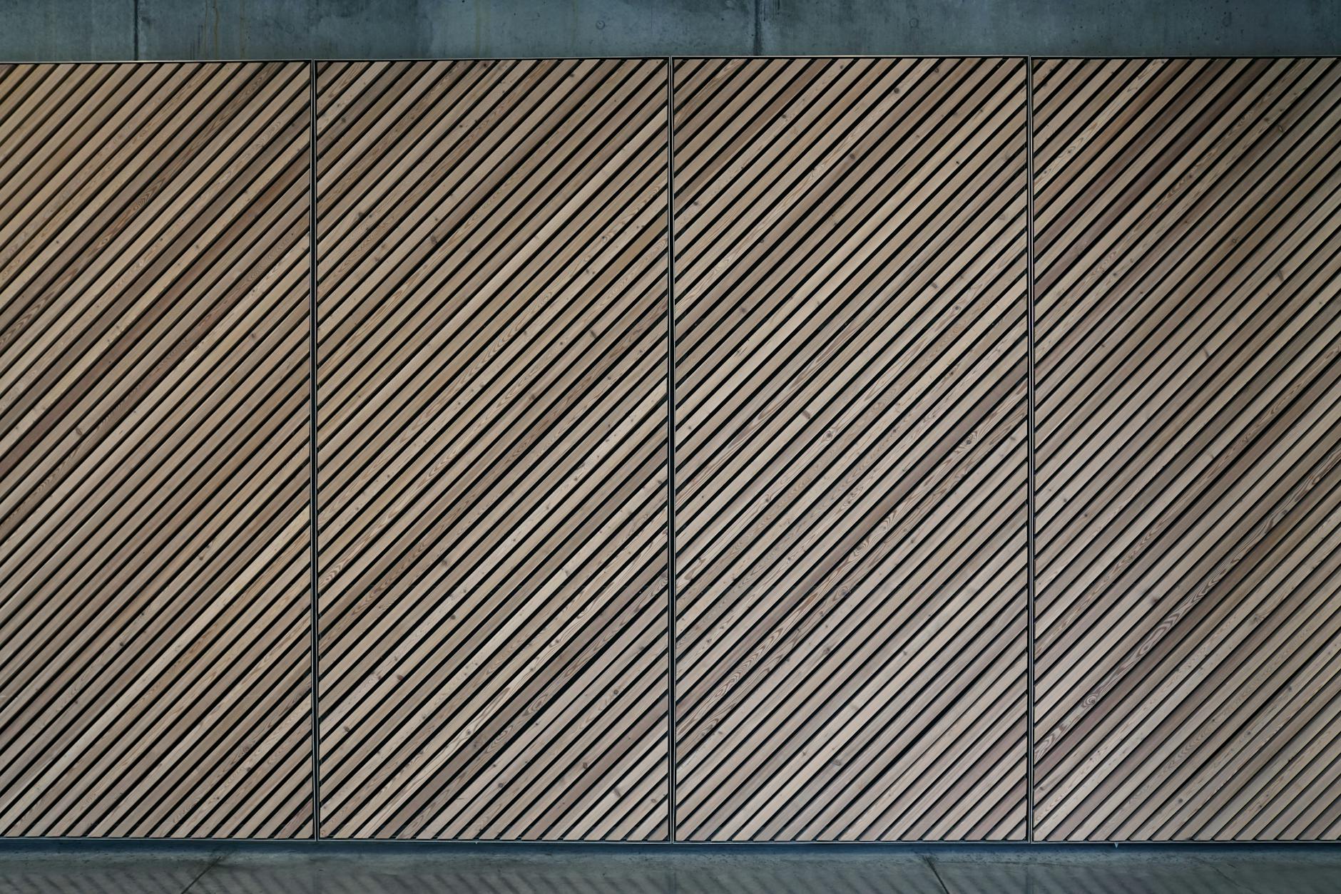 Abstract view of a diagonal wooden panel wall with a textured, patterned design.