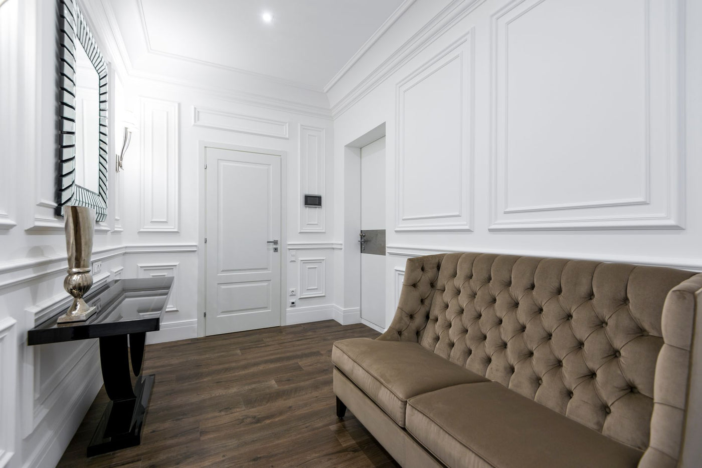 A sophisticated interior with a tufted sofa and a decorative mirror, highlighting classic design elements.