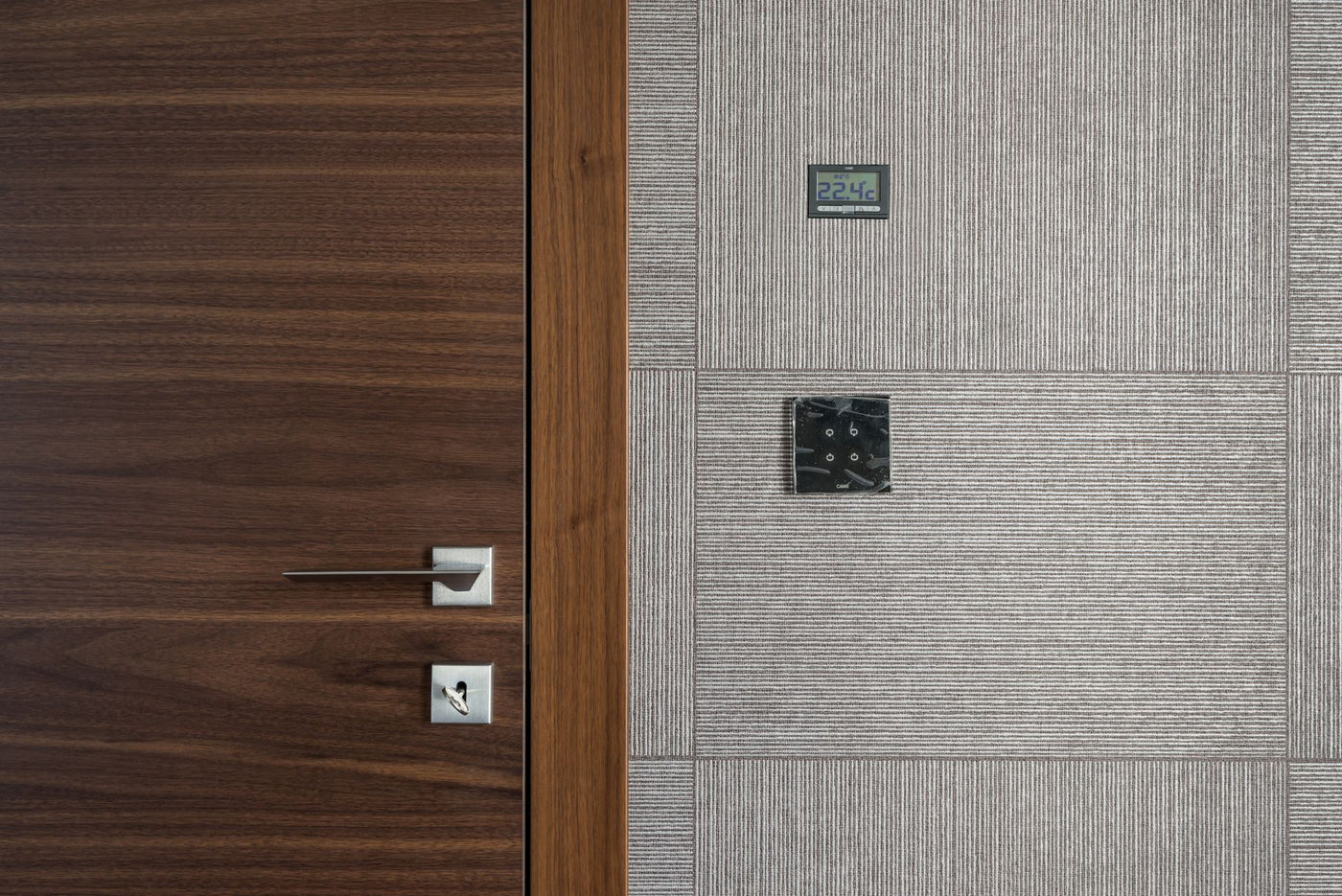 Sleek modern wooden door with stainless steel handle and 22.4°C display.