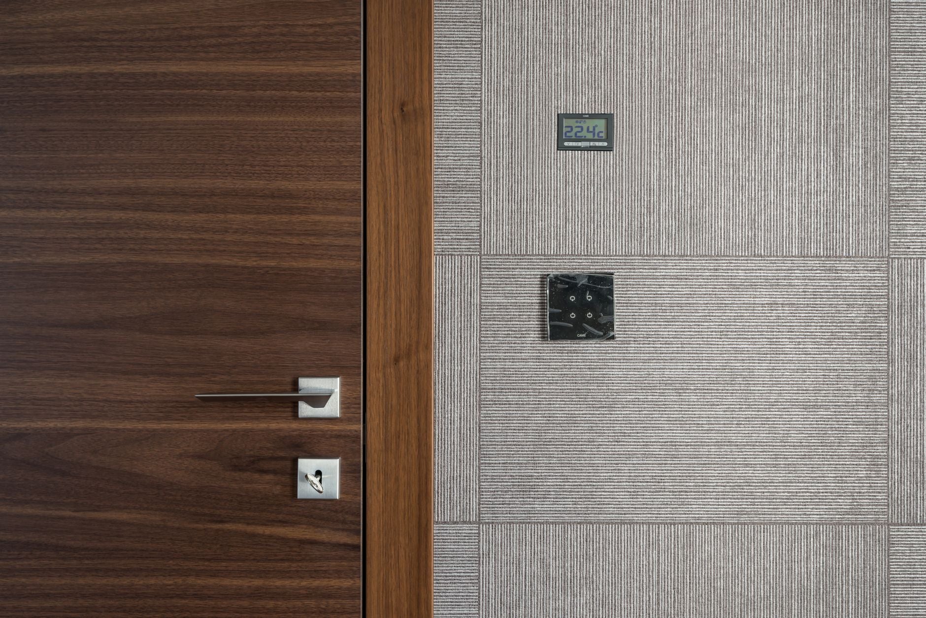 Sleek modern wooden door with stainless steel handle and 22.4°C display.