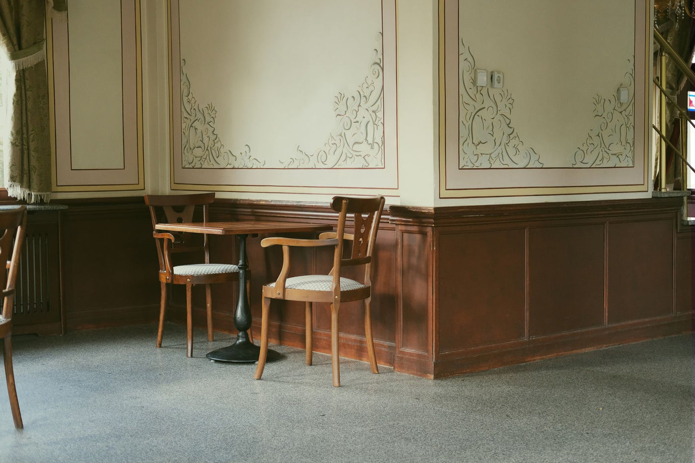 A charming vintage interior of an Istanbul café with wooden chairs and intricate wall designs.